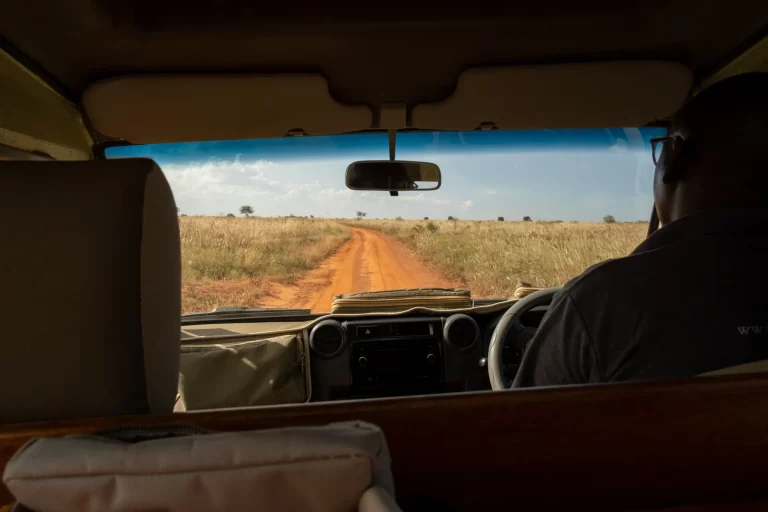Safari vehicle driving through the savanna landscape in East Africa