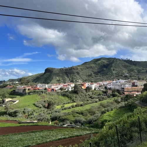 Scenic hillside town with white and terracotta-roofed buildings overlooking the Atlantic Ocean in the Canary Islands.