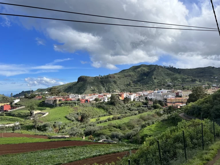 Scenic hillside town with white and terracotta-roofed buildings overlooking the Atlantic Ocean in the Canary Islands.