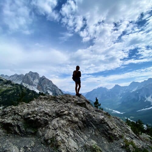 scenic mountain range with a silhouette of a hiker in the middle