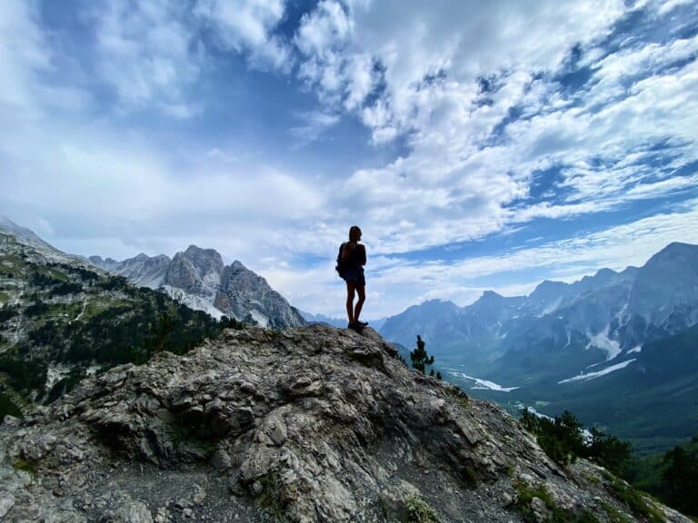 scenic mountain range with a silhouette of a hiker in the middle