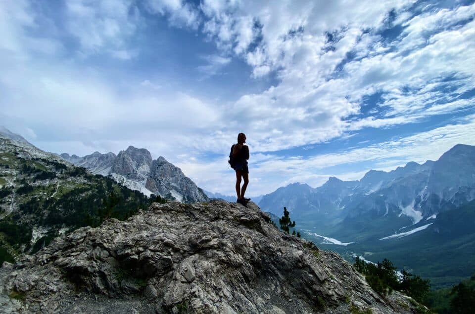 scenic mountain range with a silhouette of a hiker in the middle